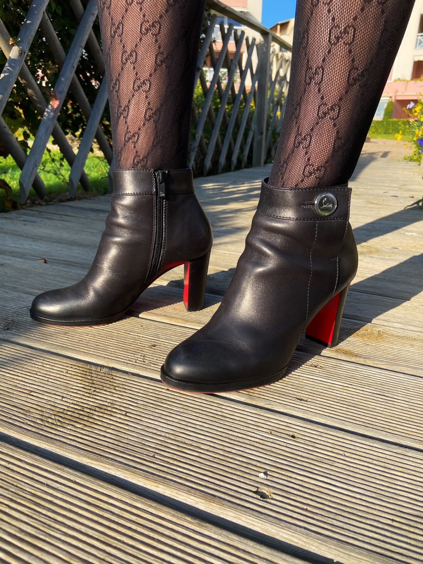 Christian Louboutin luxury black and red booties with Gucci tights